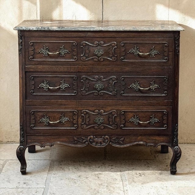 Antique Liégeoise Louis XIV Marble Top Commode is a beautiful example of timeless design bringing together the warmth of...