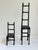 Set of two graduated cast iron ladderback style chair sculptures. Giacometti style with their elongated presence. Larger...