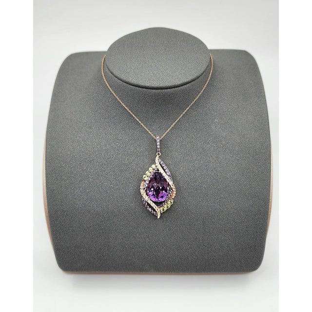 This striking Le Vian pendant showcases a magnificent 12.0 carat pear-cut amethyst, radiating a rich purple hue. The...