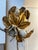 Pair of 1950s Italian wall sconces featuring gilt metal leaves with enamel floral details and original chain accents....