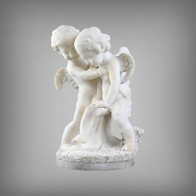 Carved from subtly translucent alabaster, this work, entitled Two Cupids Quarreling Over a Heart, belongs to the refined...