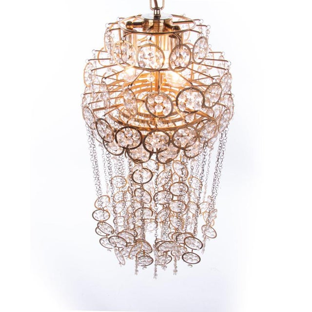 Magnificent cascading chandelier by kurt faustig with swarovski crystal elements mounted on a gilded brass structure. A...