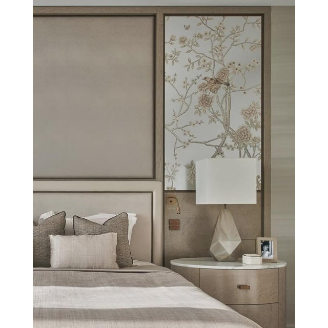 A refined hand painted silver foil wallpaper featuring delicate flowers, graceful branches, and an elegant bird motif. The...