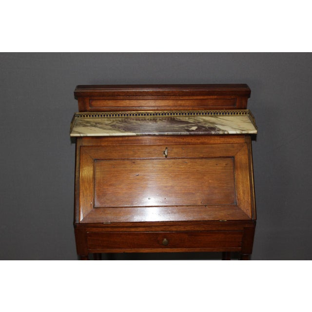 Small mahogany slant-front desk, opening with one drawer, two interior drawers, and a drop-front. Width with drop-front...