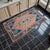 This vintage Tashpinar rug features a stunning juxtaposition of sun-faded terracotta and deep indigo blue, creating a...