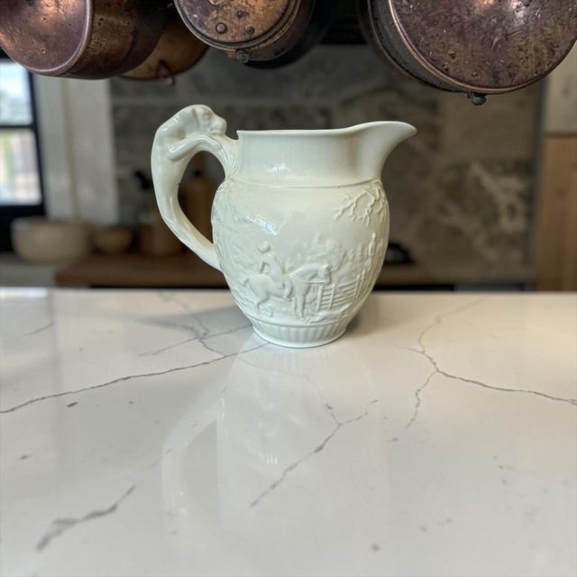 A charming vintage Wedgwood cream pitcher in the classic Queensware ivory glaze, featuring a beautifully molded fox...