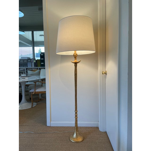 Transitional hammered iron floor lamp in gold leaf finish features sculptured and ring details with horn-like base. Topped...