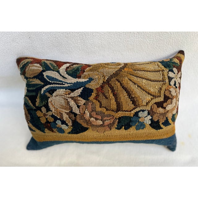 Elegant decorative pillow made from an 18th-century tapestry fragment featuring a finely rendered shell motif. The antique...