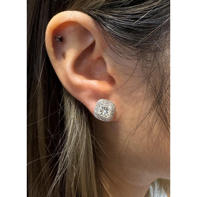 3 carat total radiant cut natural diamond stud earrings. Set in 18k white gold with a round-cut diamond halo and push-back...