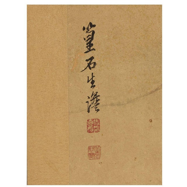 A vintage Japanese folding four panel screen showcases a serene hand-painted landscape set against a warm, gilded ground....