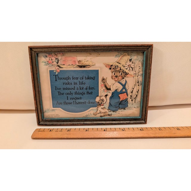 Framed color print of small black boy and his dog admiring a cake and pie with motto: "Through fear of taking risks in...