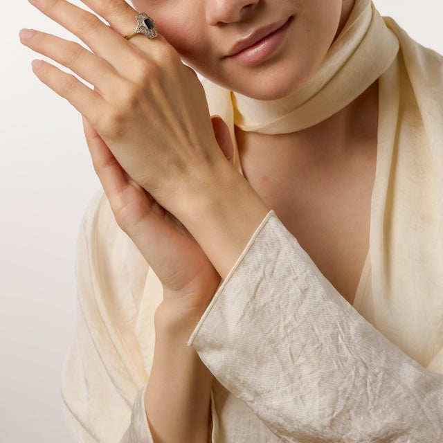 A graceful tribute to early twentieth-century refinement, this Edwardian-inspired ring centers on a vivid 1.40 carat...