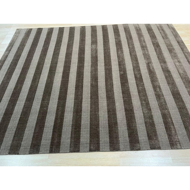 A hand-knotted wool rug, made in India and measuring 4' x 6'. Geometric drawing - repeating motifs held inside strong...