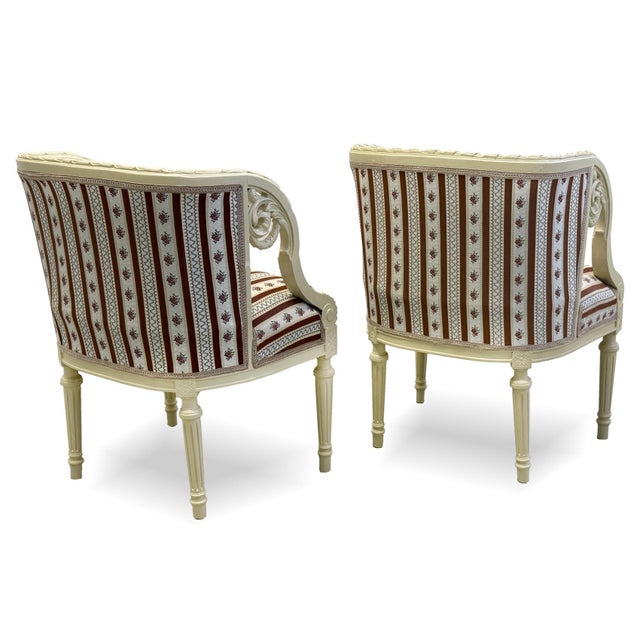 A pair of Rococo Revival armchairs dating from around 1870. These elegant armchairs feature richly carved armrests, finely...
