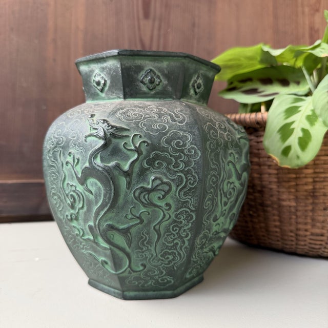 This Japanese bronze vase dates from the Shōwa period, around the 1960s–1970s. The piece has a strong octagonal form, with...