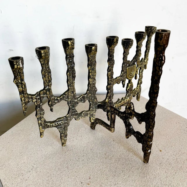 This stunning vintage brass Menorah embodies the bold Brutalist style with its raw textures and intricate design. Crafted...