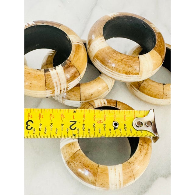 This set of six carved bone napkin rings adds a touch of rustic elegance to any dining table, showcasing intricate...