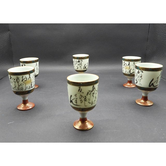 This marvelous set of 6 vintage 1960s Japanese sake glasses are created in a gorgeous white porcelain with black Japanese...