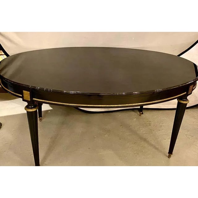 Louis XVI Jansen style center or dining table in a black lacquer steinway piano finish. This Hollywood Regency spectacular...