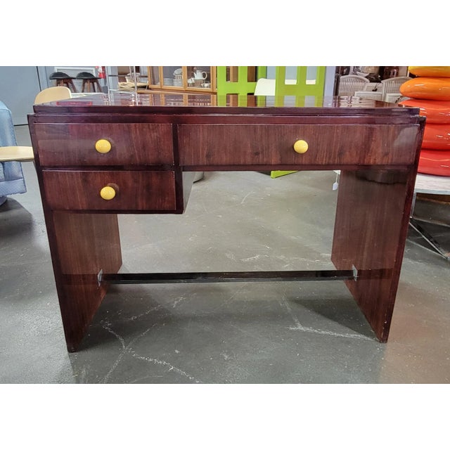 Great writing desk has dark burgundy stain with a lacquered finish, 3 drawers and a foot rest underneath. Our purpose at...