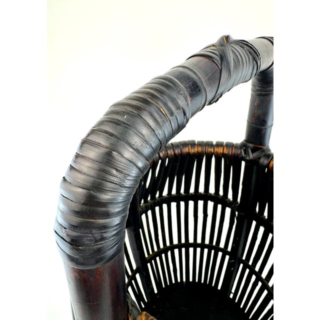 This vintage black rattan basket features a beautifully sculptural silhouette with vertically woven rattan forming an...