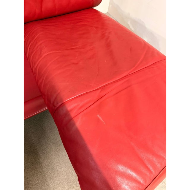 The iconic De Sede DS-140 two-seater sofa is upholstered in red leather with a metal/steel frame. It features adjustable...