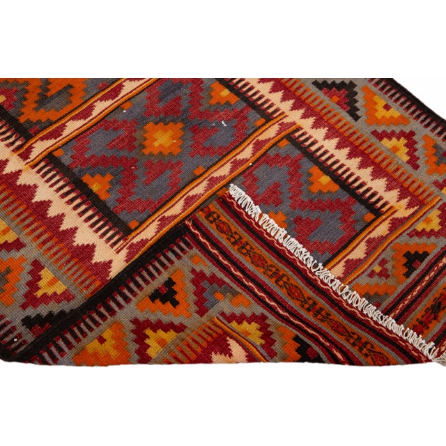 Beautiful kilim handmade wool runner with a orange field. This Vintage flatweave rug features a gorgeous all-over...