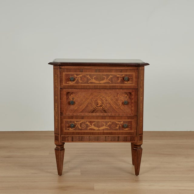 Charming antique Italian chest crafted in walnut featuring a top with a center medallion of an inlaid bird embellished...