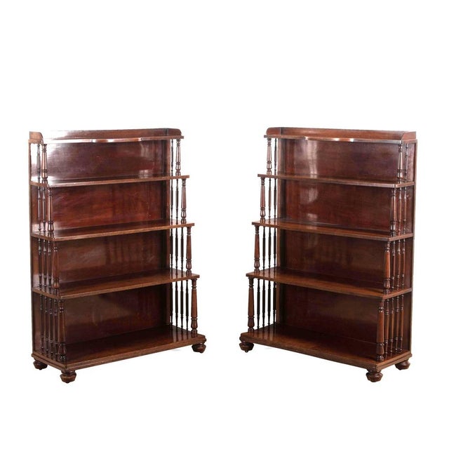a smart pair of regency mahogany waterfall open bookcases, with low gallery to the top shelf and bow centre section, above...