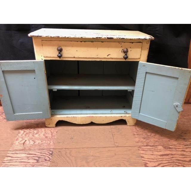 Darling light yellow shabby chic cabinet. One shelf behind the cabinet doors and a drawer. Inside is painted a faded light...