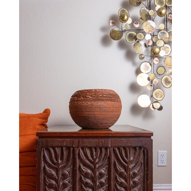 Dimensions: 12"D × 8.5"H Sculptural terracotta planter with a low, rounded form and deeply textured horizontal ribbing....