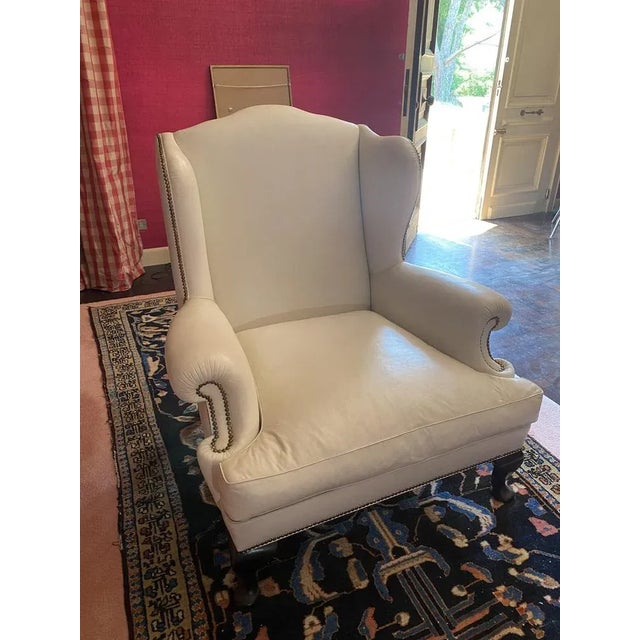 Armchair with pouf. Chesterfield nineteenth -century queen Anna, lined with white leather with studs and wooden feet....