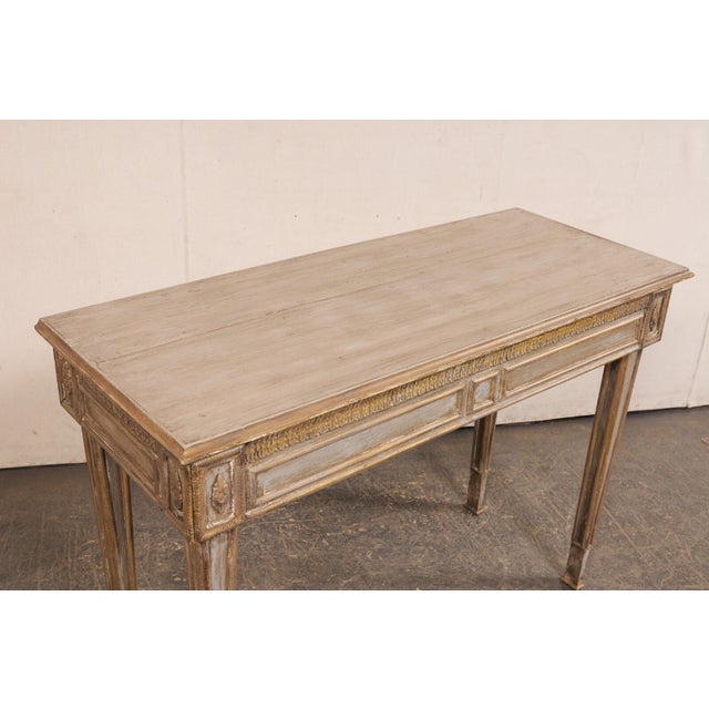 An Italian wood-carved console table, with new custom painted finish, from the early 20th century. This antique table from...
