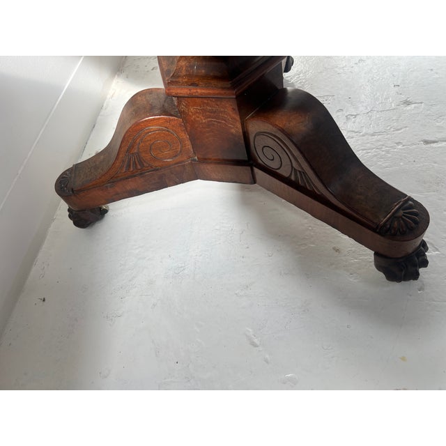 Round Empire-style mahogany and veneer side table Tripod base with claw feet The central column is faceted "Gris St. Anne"...