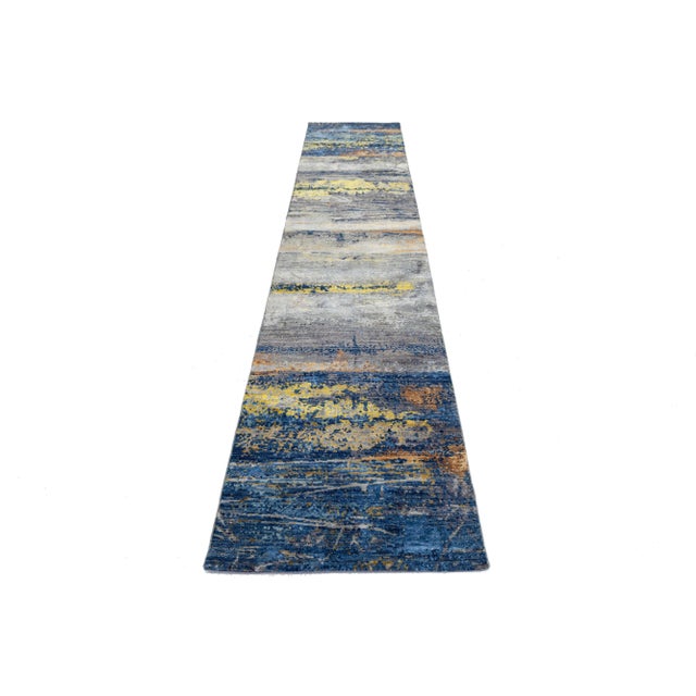 This contemporary hand-knotted rug boasts a striking abstract design and a vibrant color palette. Made from high-quality...