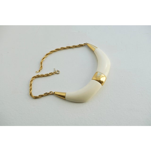 Vintage Crown Trifari statement choker necklace from the late 1960s–1970s. The piece centers on a cream resin double horn...