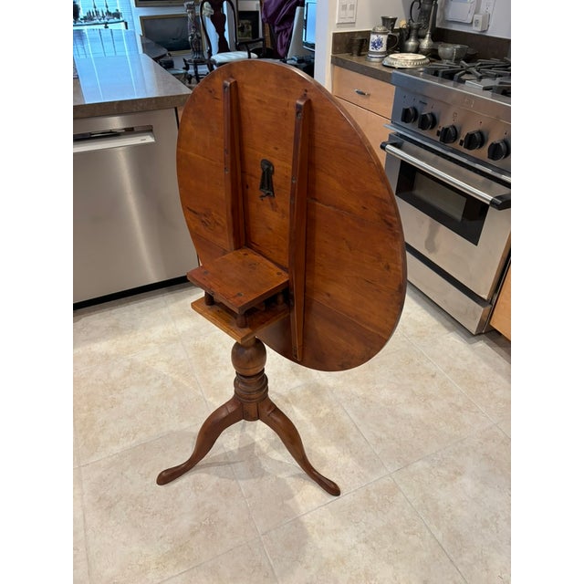 This tilt-top, birdcage table that spins and tilts is believed to be made of walnut. Manufacturer and exact date of...