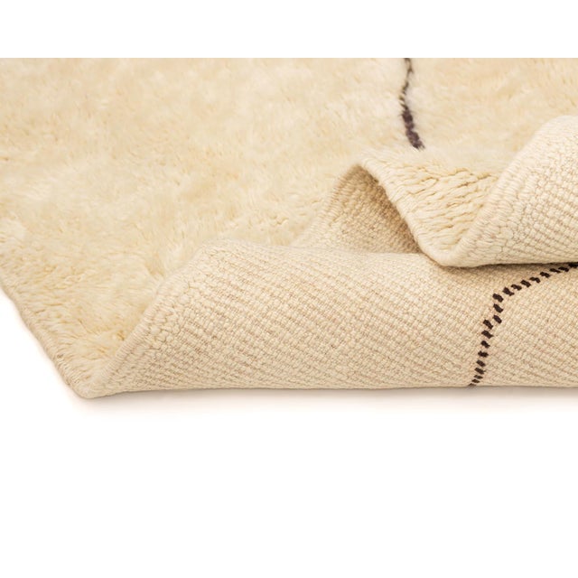 Minimalist hand-knotted wool rug featuring a clean Ivory backdrop with a singular Chocolate Brown diamond shape edged with...