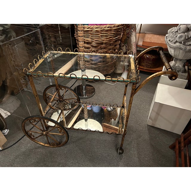 Charming small two tier gilt iron Italian vintage bar cart having scalloped decorative galleries and pretty decorated...