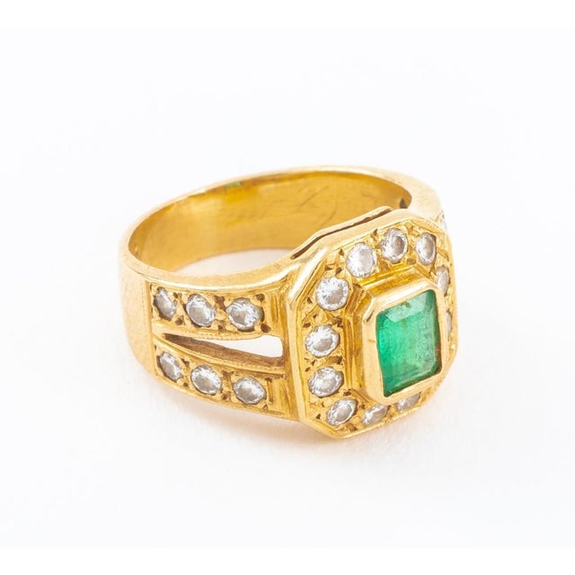 14K yellow gold ring, brightly polished, featuring a centered bezel set emerald, weighing approx. 0.35 ct, further...