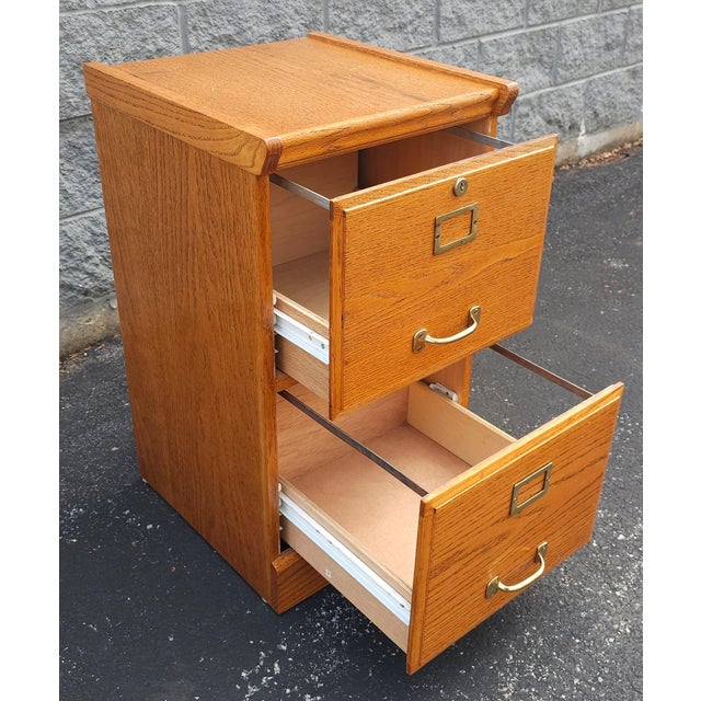 This handsome oak file cabinet offers both style and practicality. Featuring a rich oak finish complemented by solid wood...