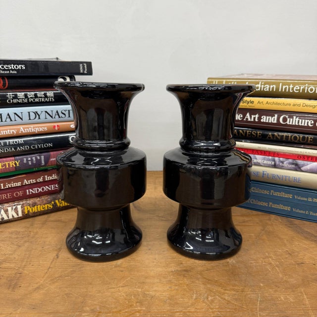 "About This Piece About This Piece Bold, sleek, and timeless, this pair of black ceramic vases captures attention with...
