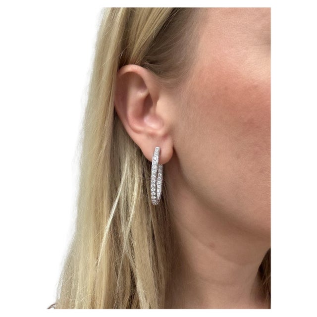 In a modern design with a twist! These hoop earrings contain round brilliant cut diamonds weighing approximately 12.08...