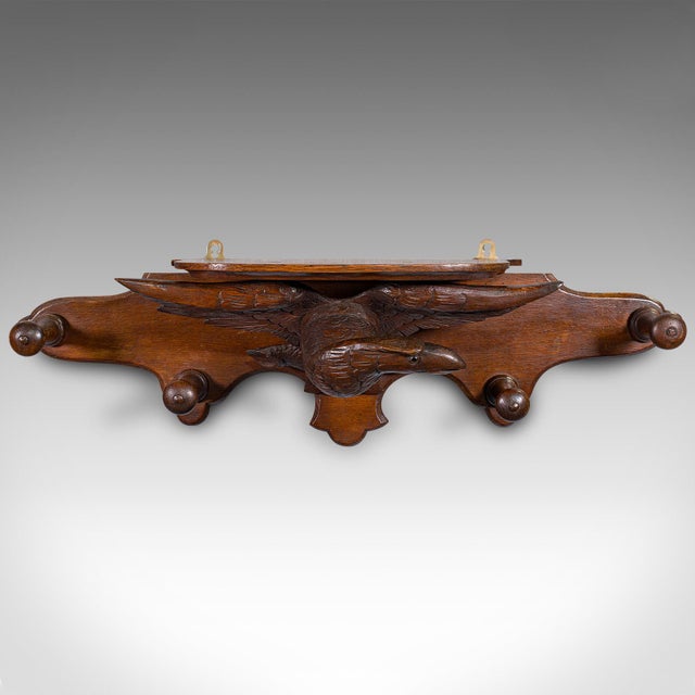 This is an antique carved eagle coat rack. A Scottish, oak hallway peg mount, dating to the late Victorian period, circa...