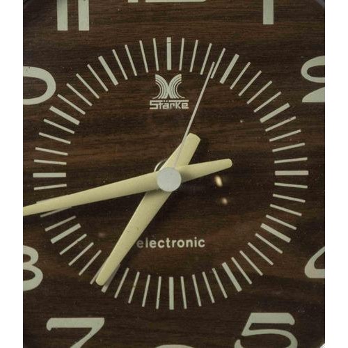 Mid-Century Wall Clock inMetal and plastic, with wood-veneer dial. Battery-operated quartz movement Circular chrome-toned...