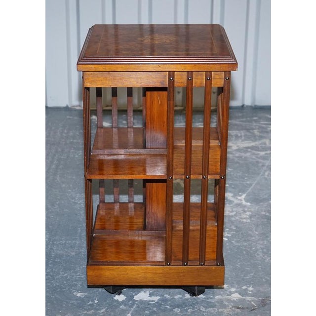This elegant vintage revolving bookcase features a beautifully figured burr walnut top, showcasing rich grain patterns and...