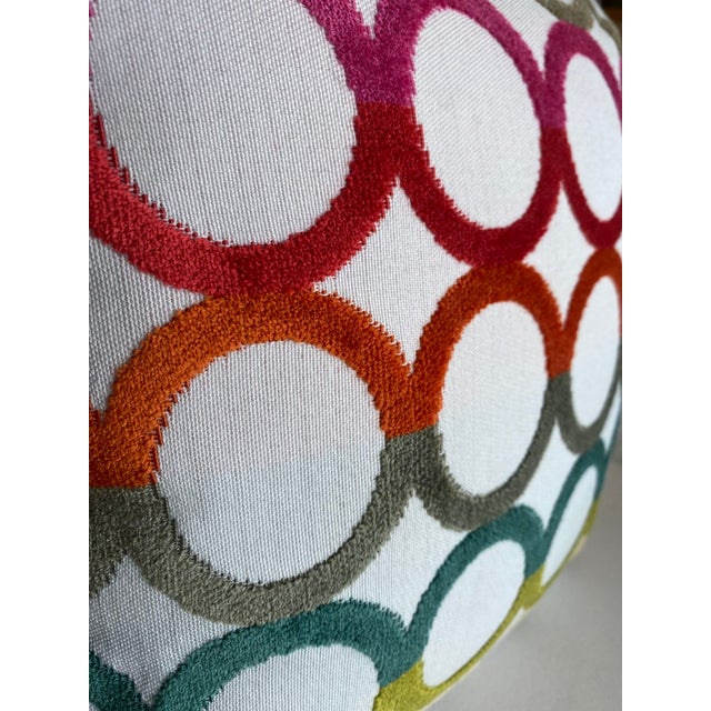 This pillow features a vibrant chain-link pattern in a rainbow gradient of colors, from warm pinks and oranges to cool...
