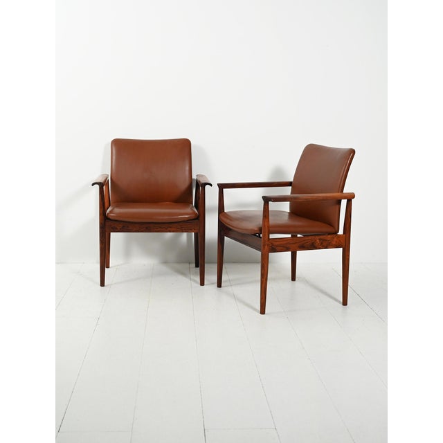 Pair of "Diplomat" chairs by Finn Juhl for France & Son, 1960s. Original rosewood and cognac leather, with the maker's...