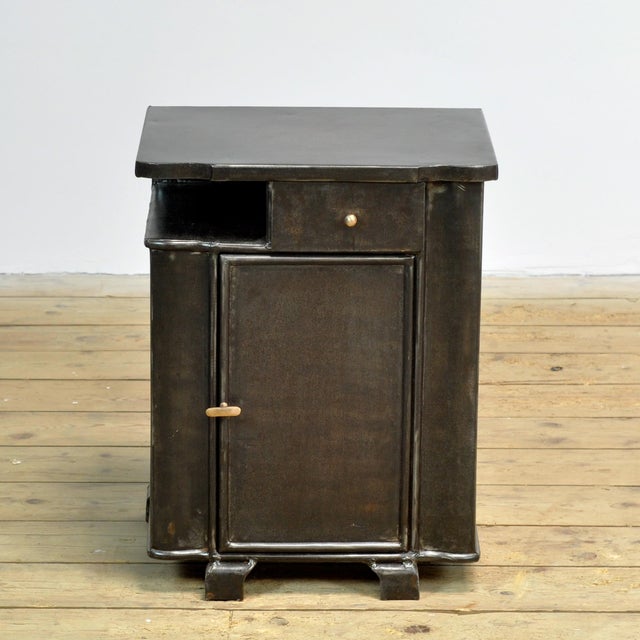 Bedside table from the 1930s with a characterful, industrial look. The cabinet features an elegant, curved front that...