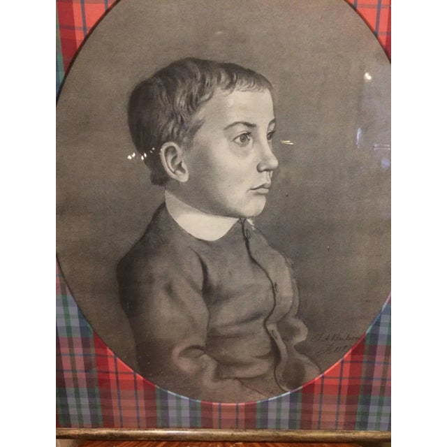 19th century charcoal portrait of a pensive little boy imaginatively matted as an oval surrounded by fancy plaid taffeta...